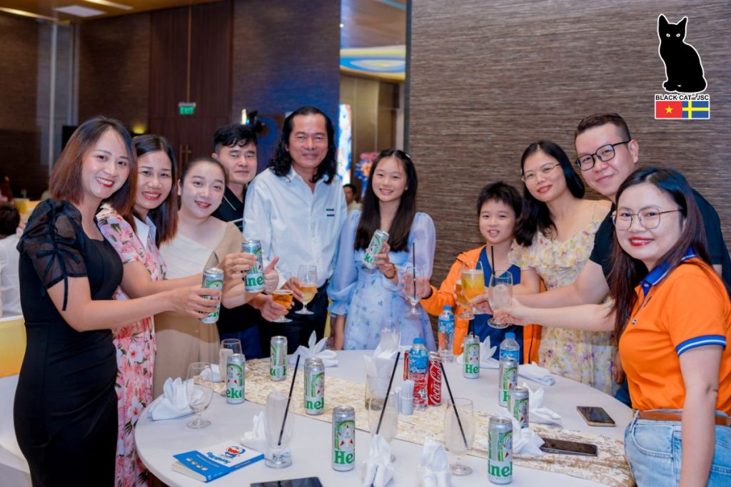 All staff members gathered around the table, raising their glasses in celebration and enjoying a cozy dinner together.